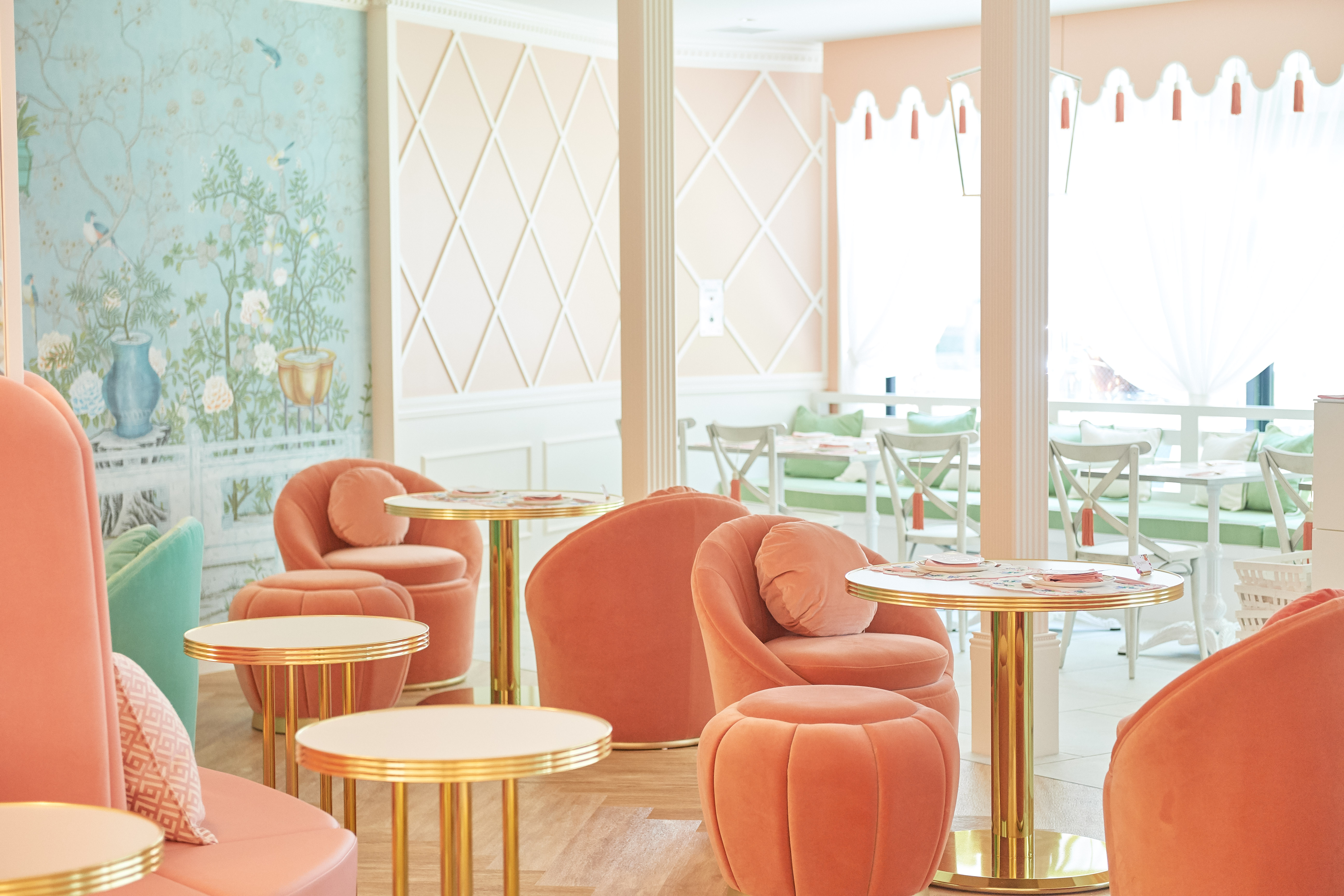 pale pink velvet chairs and stools inside a pastel-colored tea room