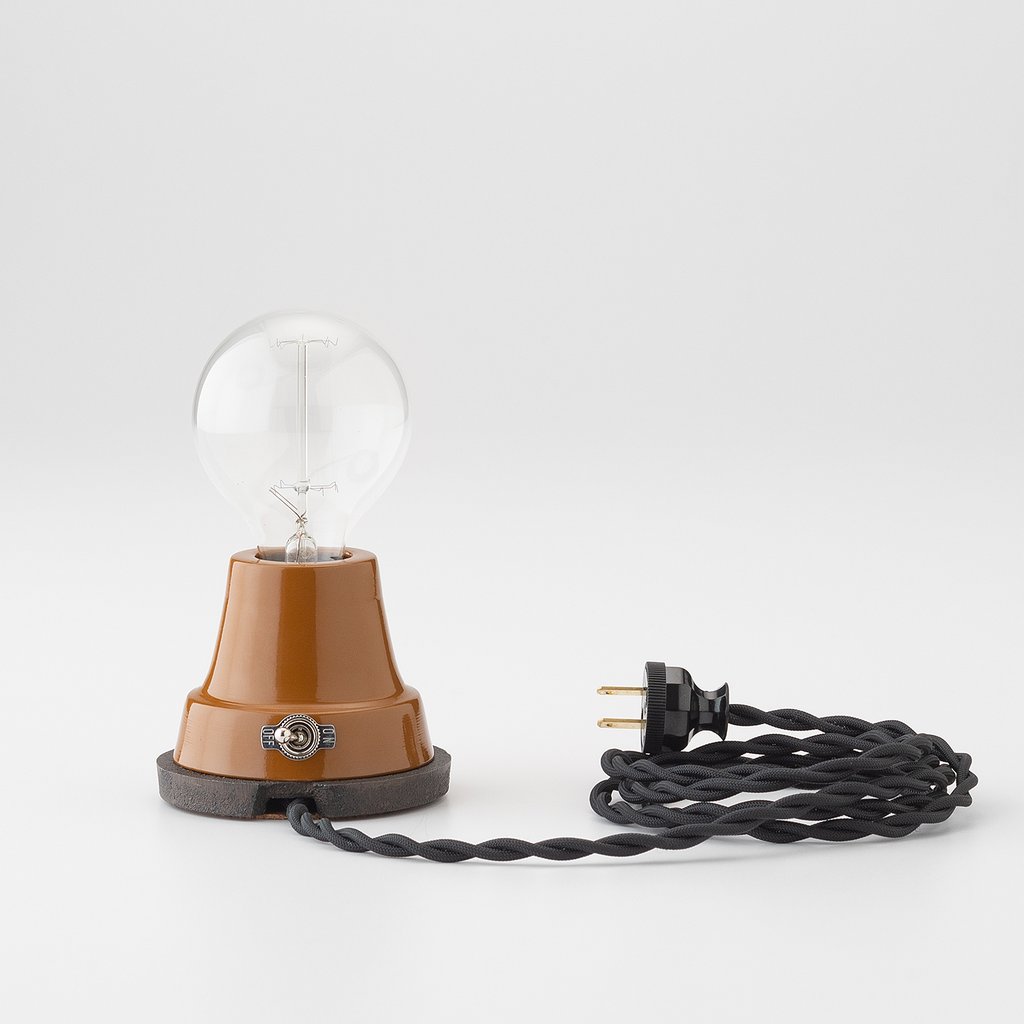 glossy table lamp with cloth cord and exposed bulb