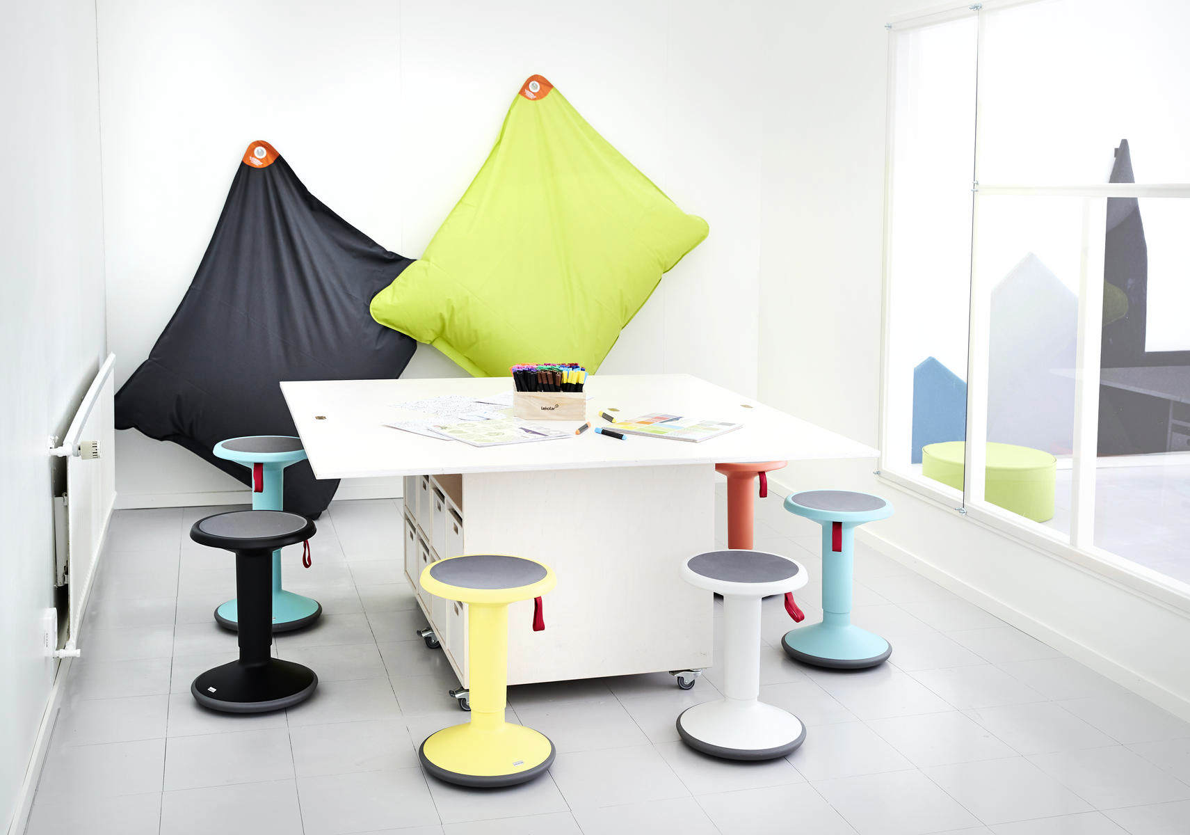 office meeting table surrounded by colorful plastic stools