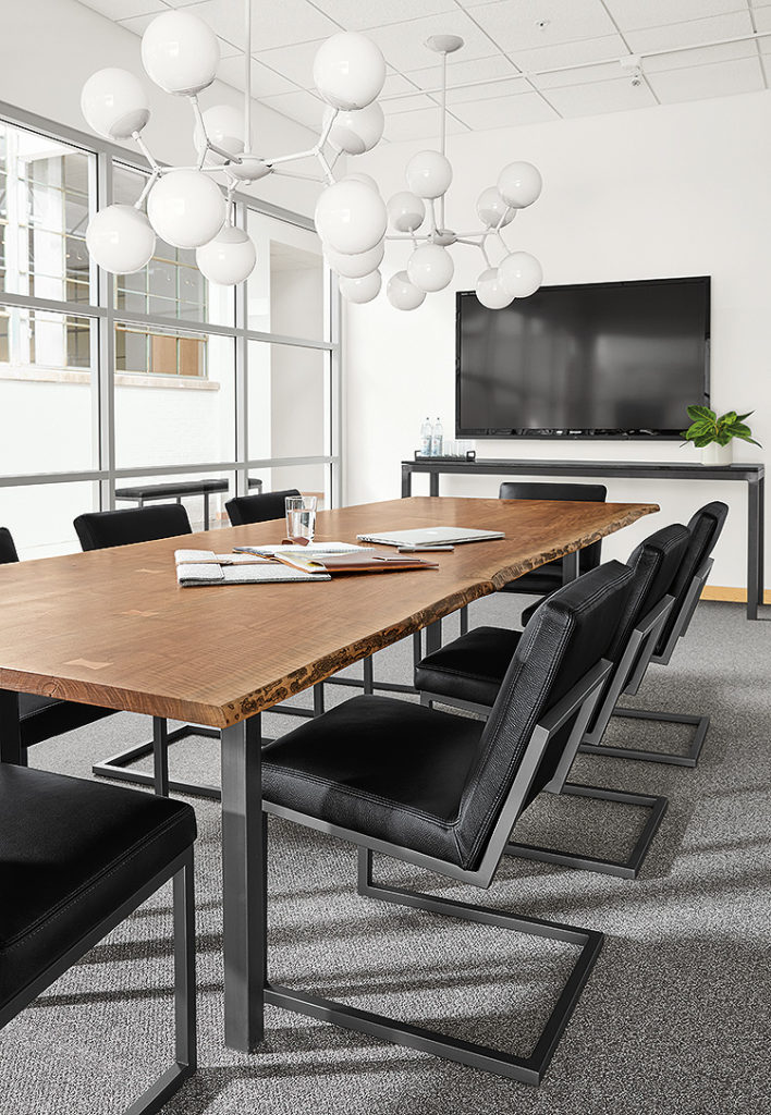 Room & Board Business Interiors Chilton Conference Table with black chairs in conference room with large tv monitor