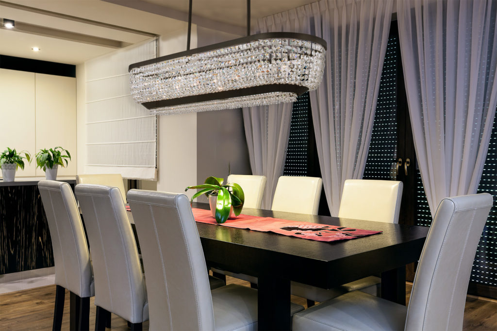 Allegri Crystal Terzo chandelier of crystal beads strung together in boat-like shape above dining table in spare dining room