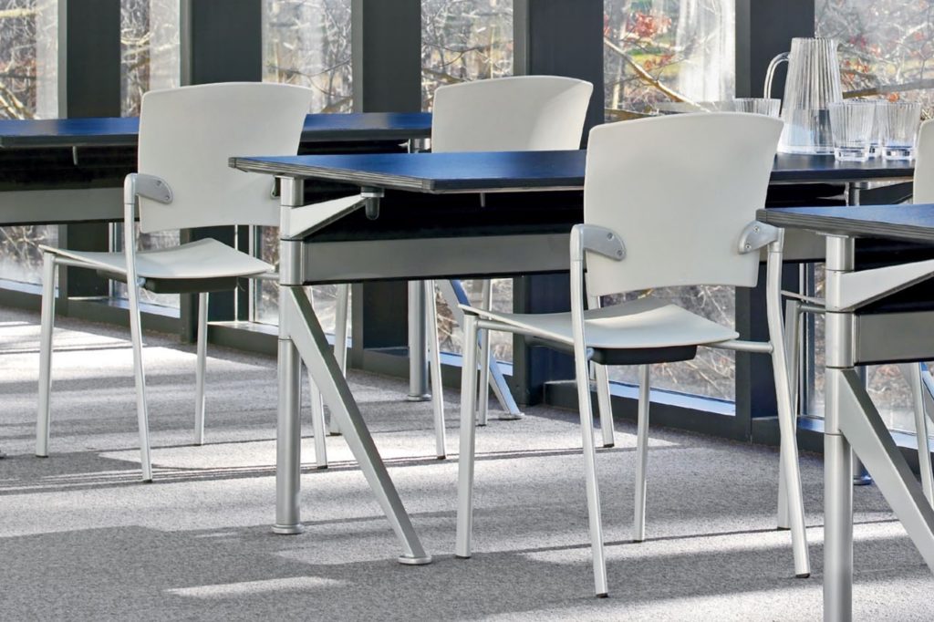 Douglas Ball Ballet Table partial views of three tables with blue tops and silver bases accompanied by white chairs in light-filled office 