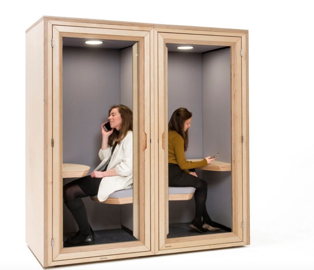 Spacestor Residence Work Privacy Pod in laminated wood. Two units with a woman on the phone in each. 