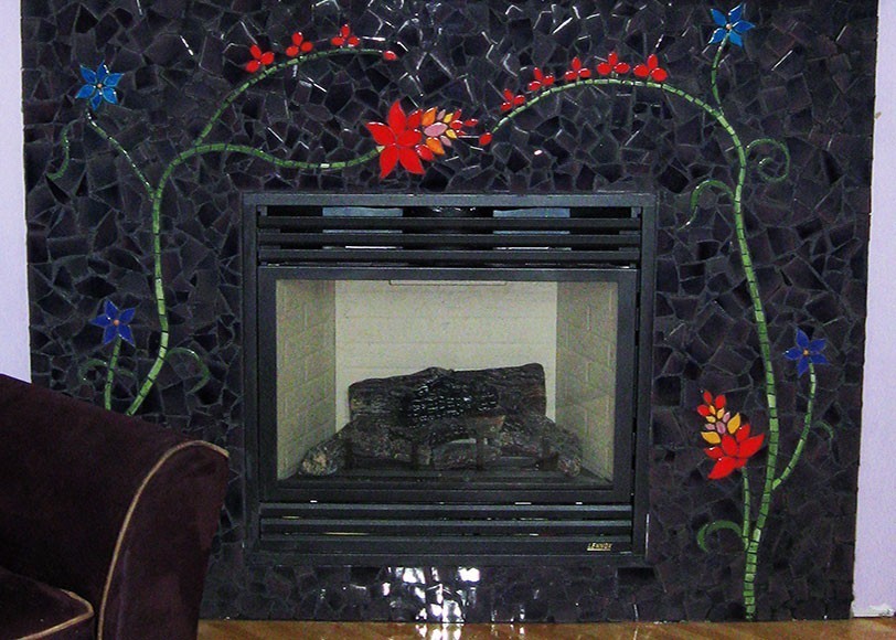 BonTon designs custom fireplace surround dark jagged shapes with two long-stemmed flowering plants