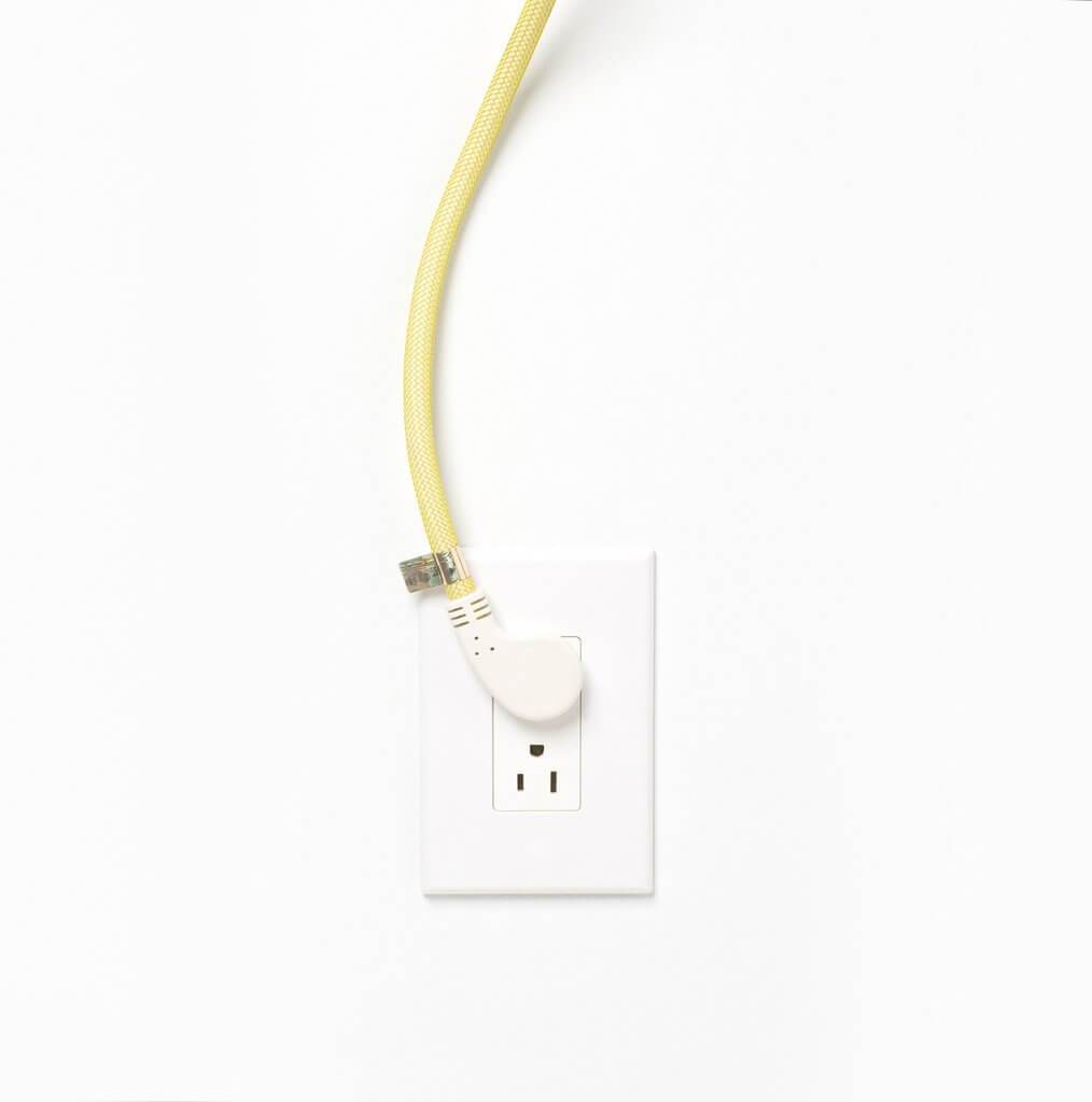 Most Modest's Niko power pendant with yellow cord detail of plug in wall
