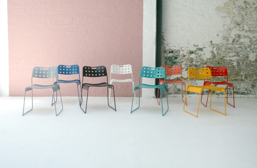 Sandler Stak Chair all eight colors in front of wall outdoors