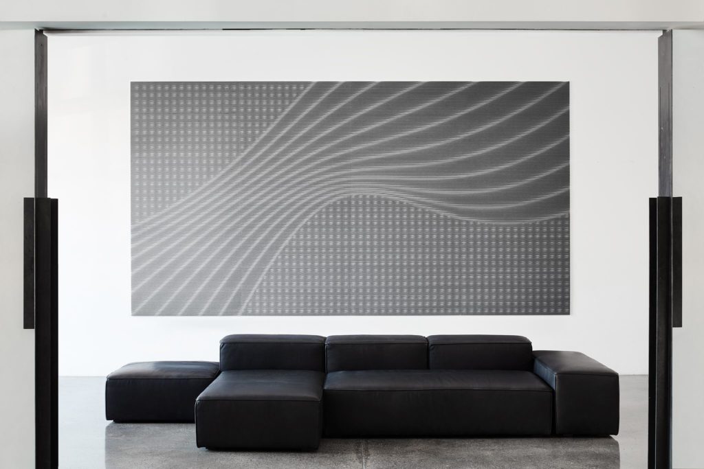 Scanlines acoustical panels front view of gray sound wave with black sofa beneath