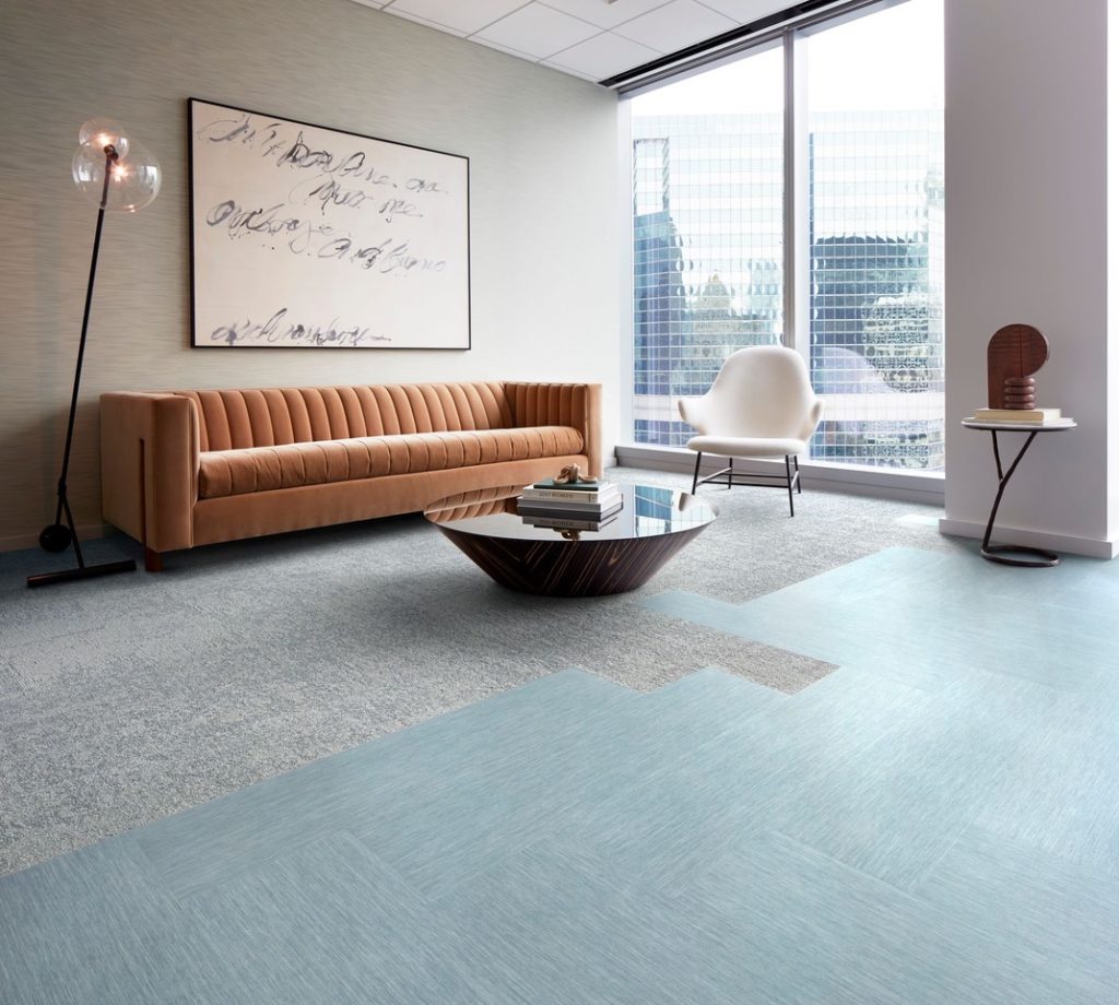 Product Intelligence LVT and modular carpet by Interface in open room with sofa and chair