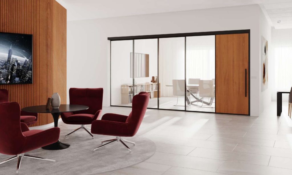 Muraflex Expo telescoping door system black with wood door incorporated and red lounge chairs in foreground