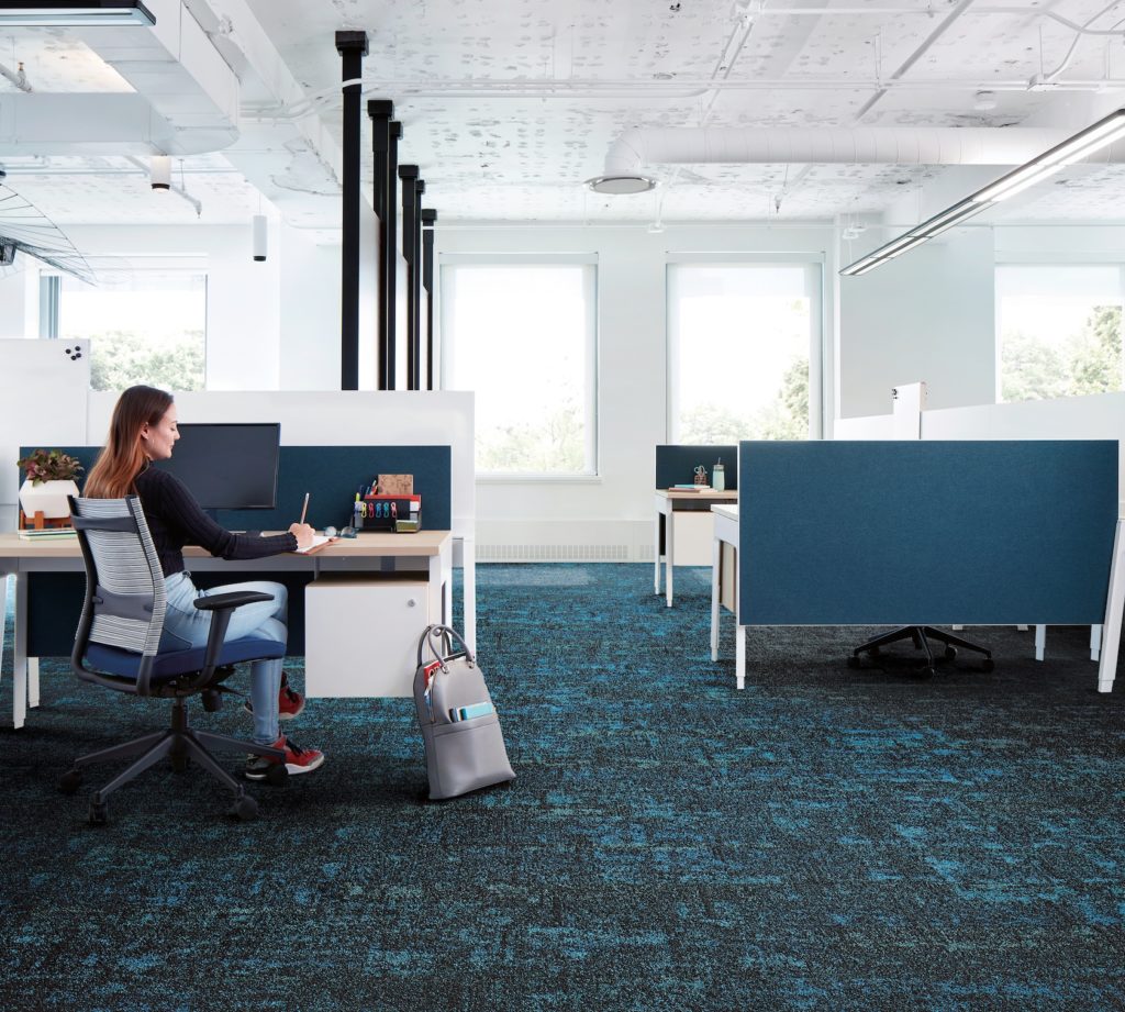 Rising Signs Carpet Tiles Up at Dawn in blue and black in office with cubicles and woman working 