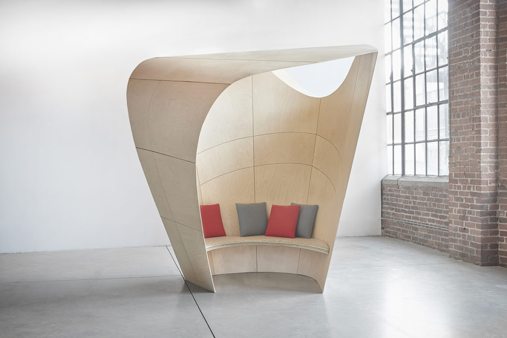 Patkau Cocoon in open space with brick wall and red/gray cushions
