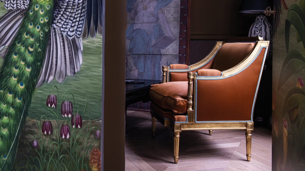leather lounge chair by Maison Taillardat near tapestry wtih bird feather theme and tulips