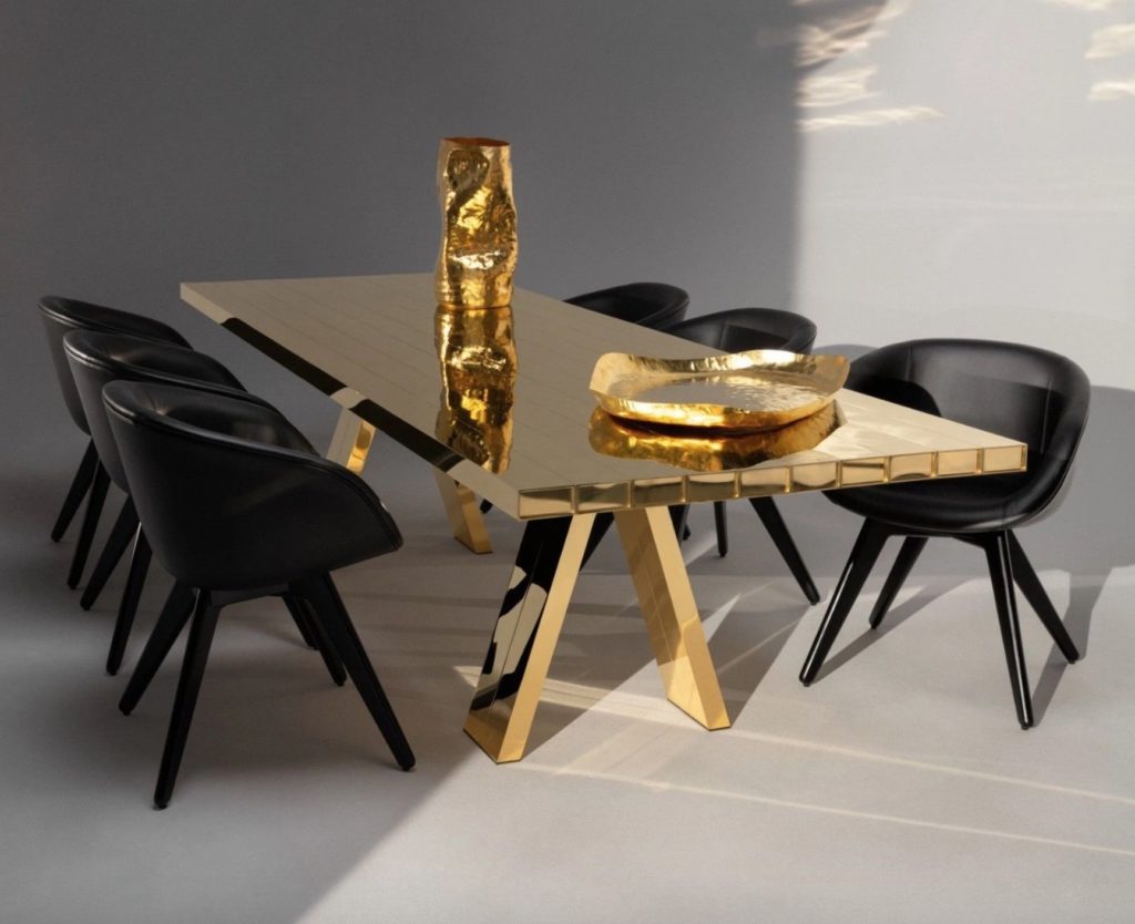 brass Mass table with black chairs and brass accessories 