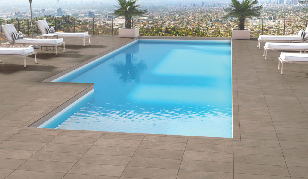 porcelain tile Portugal collection in beige surrounding pool with city backdrop