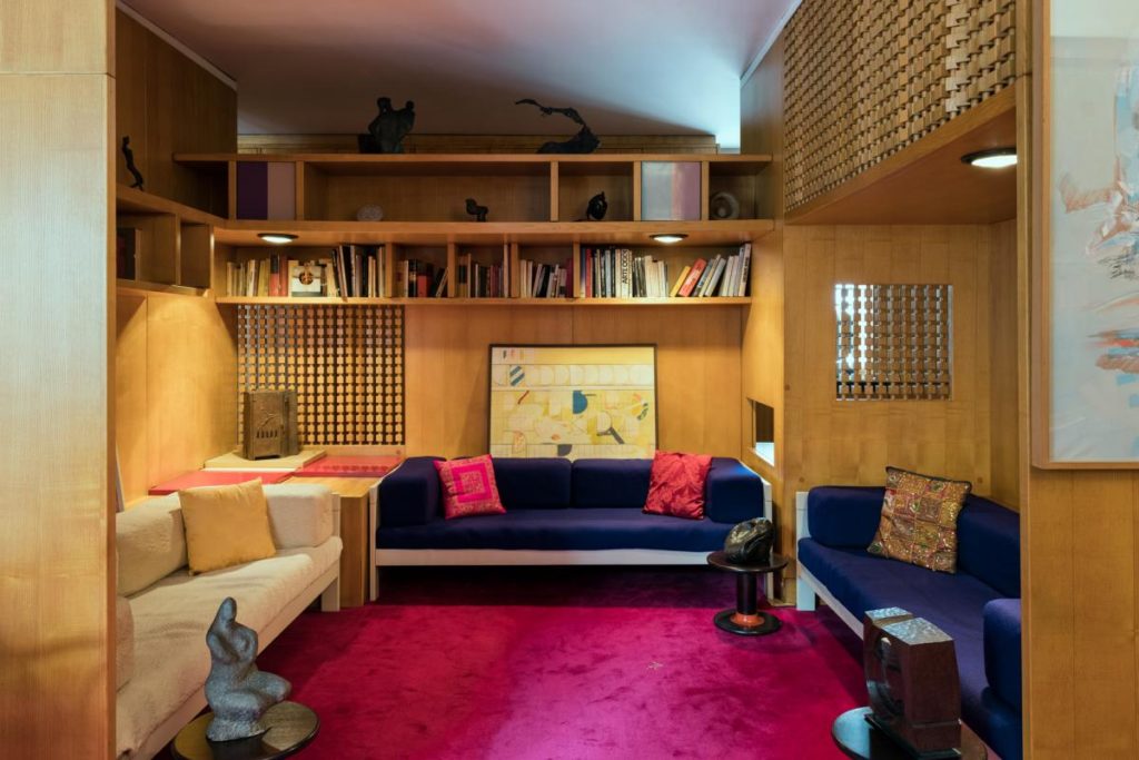 Casa Lana main room with multiple sofas, red carpet and built-in bookcase
