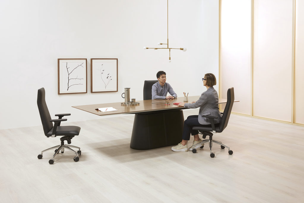Large Nienkämper table with two people seated and talking