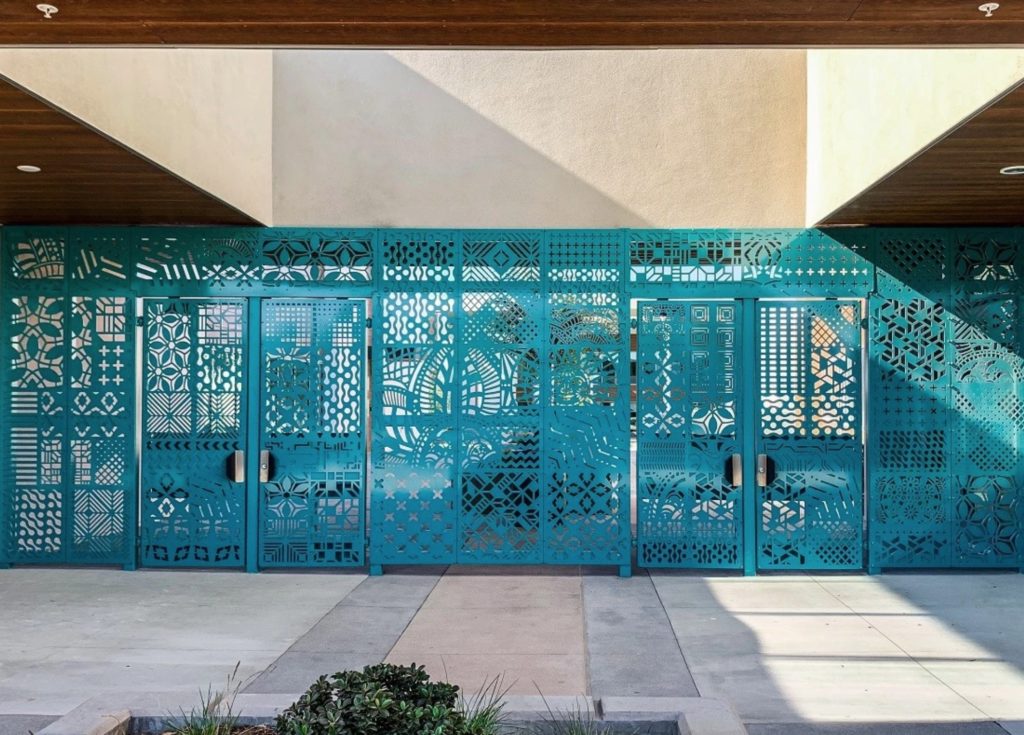 Parasoleil custom gate at Logan School with blue tint and different designs suggesting Mayan iconography