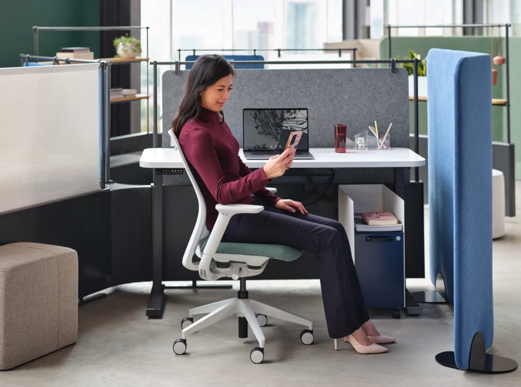 Allsteel office privacy screen with blue felt and seated woman looking at phone