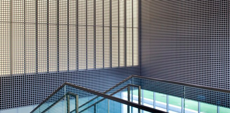 Perforated metal panels in open stairwell