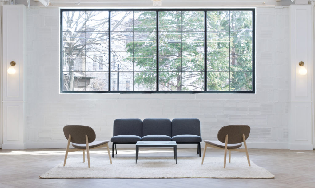 Source International chairs and sofa in open room beneath window