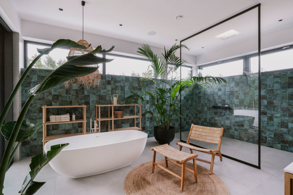 Temple bathtub in lush bathroom with large shower and lots of greenery