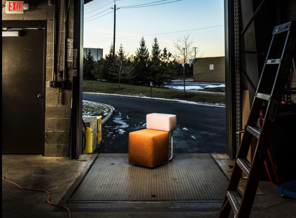Square Chair with orange/pink in garage open to the outside 