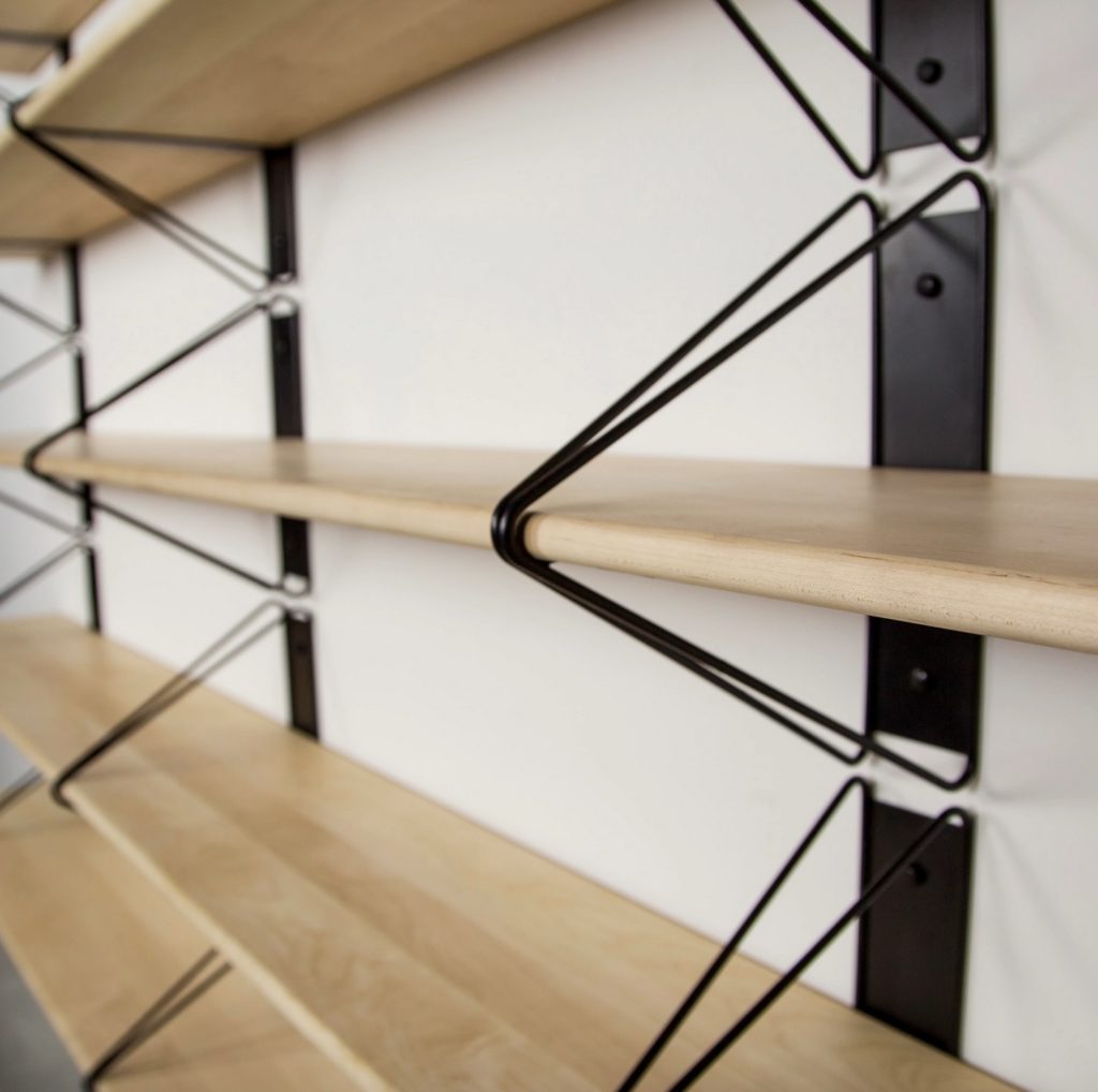 close-in view of book shelf system with black hardware and wooden shelves