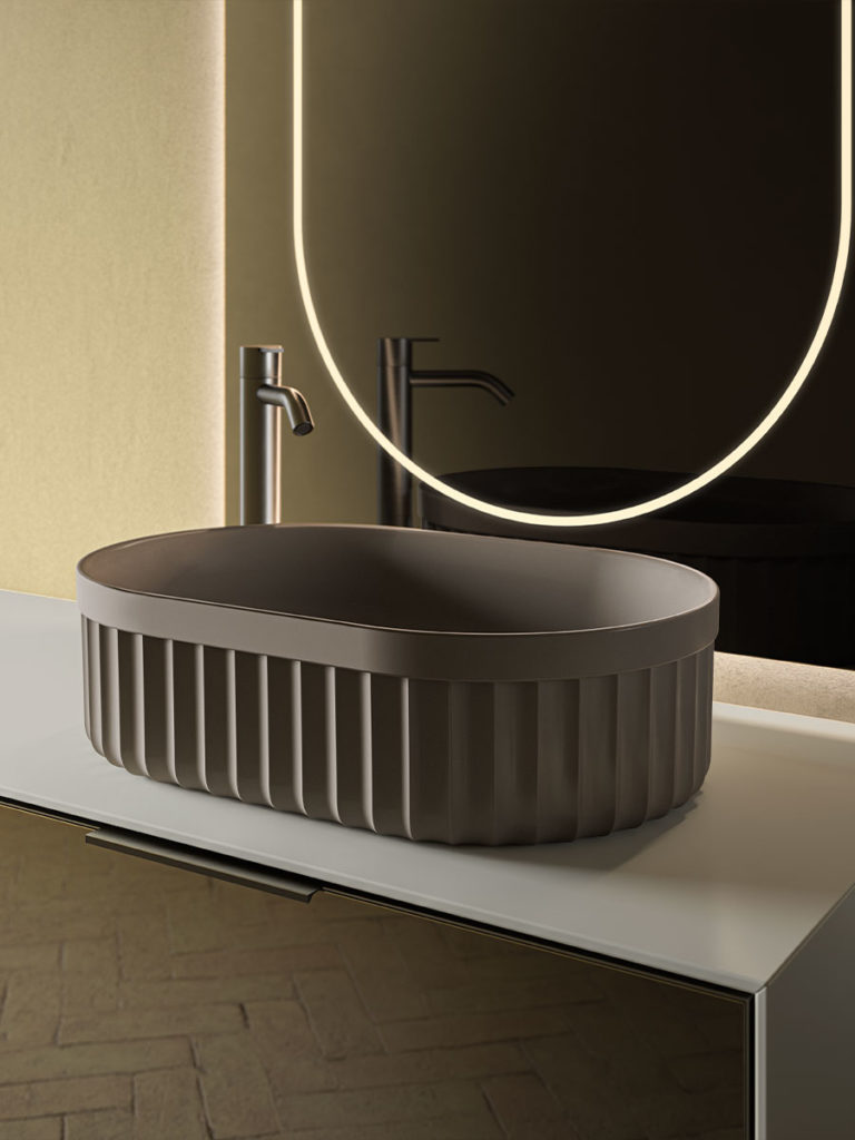 close-in view of an oval-shaped counter-top washbasin with mirror behind