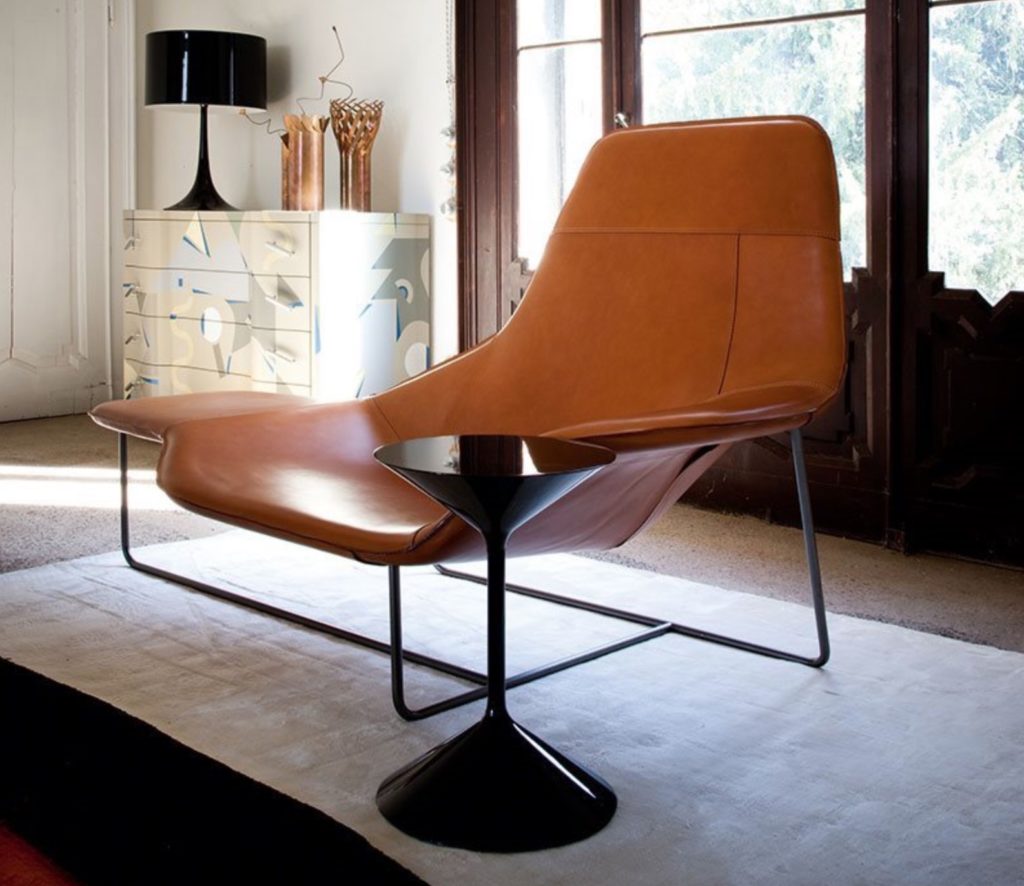 Lama lounge in leather close in with black pedestal table that looks like an hourglass