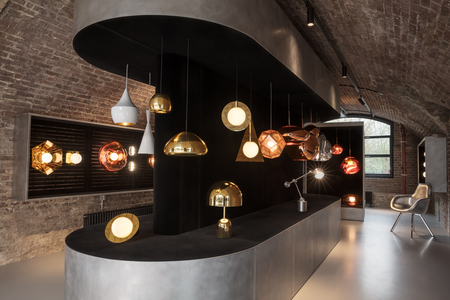 collection of brass metal and glass designer suspension lamps inside brick building