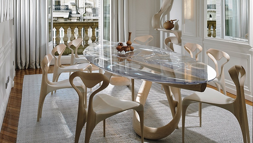 glass dining table surrounded by armless chairs in bleached ash