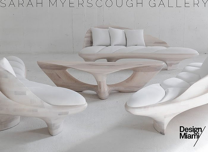 three bleached ash benches with upholstered cushions surrounding a sinuous wood coffee table