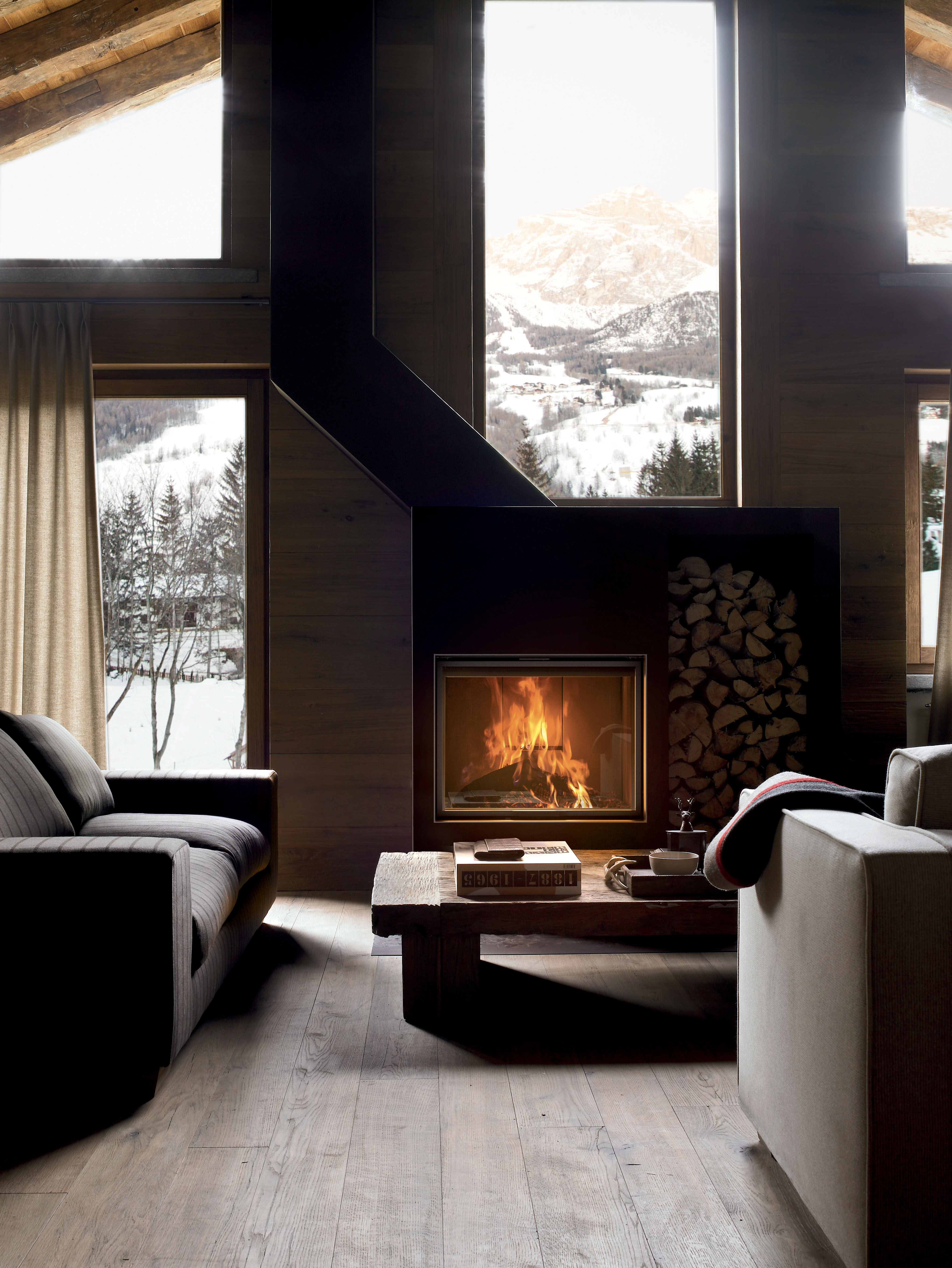 MCZ Wood Burning Fireplace in living room with wood stack and mountain scene outside