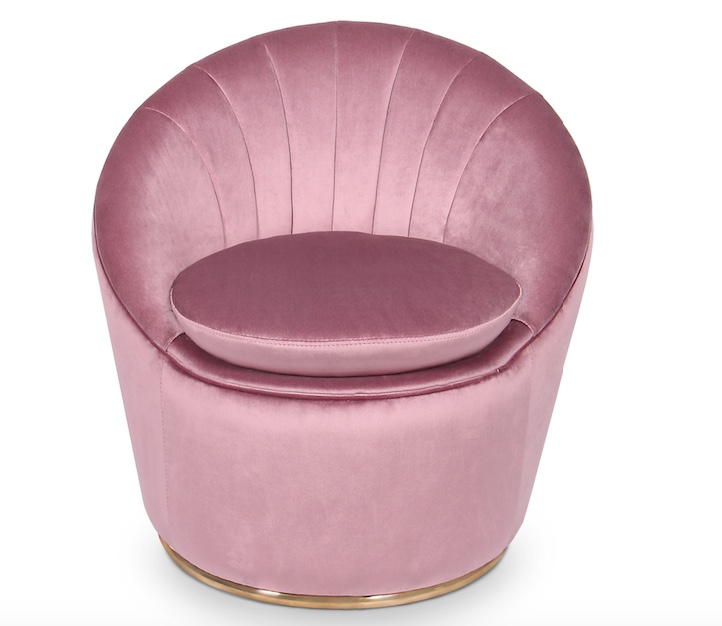 pink clamshell-shaped velvet armchair against white background
