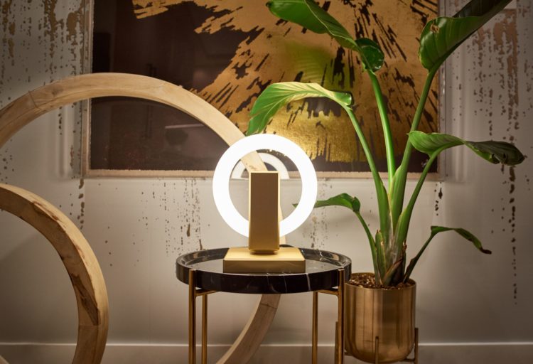 Karice Olah Table Lamp on luxury round table with sculptural ring forms in background