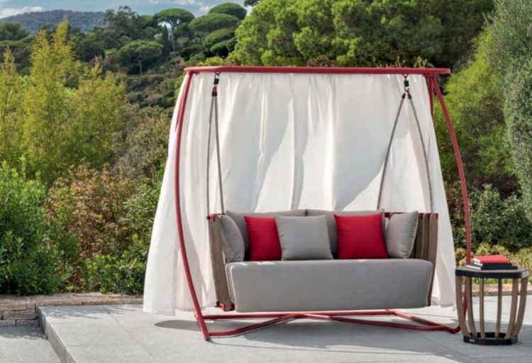 outdoor lounge swing for two people with red metal frame, teak sofa, and white fabric covering