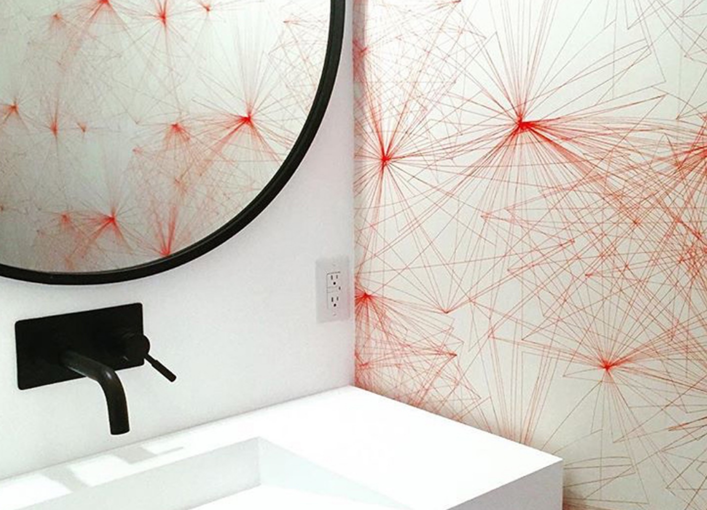 bathroom wall with red and white geometric wallpaper
