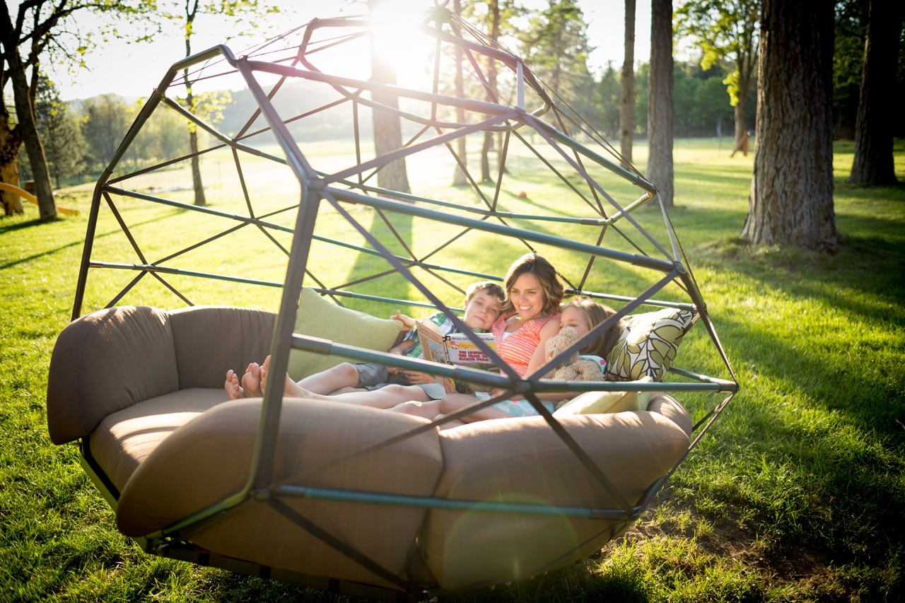Large Zome outdoors with woman and two children lying down inside