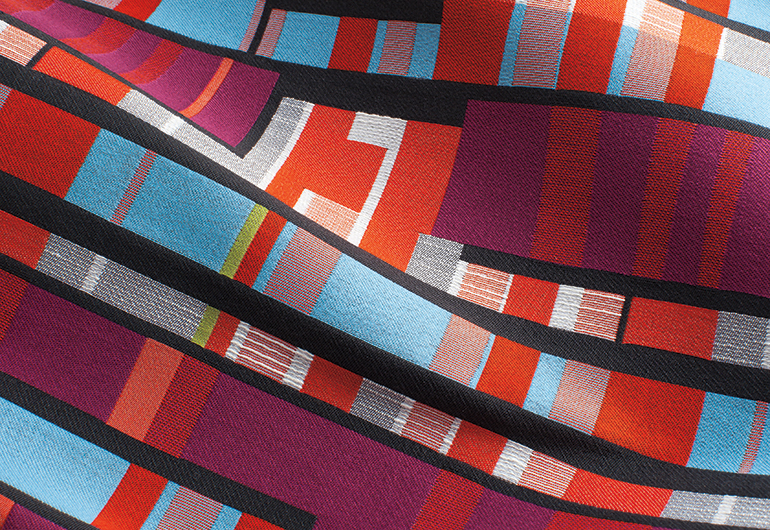 detail of brightly colored fabric with lines and squares