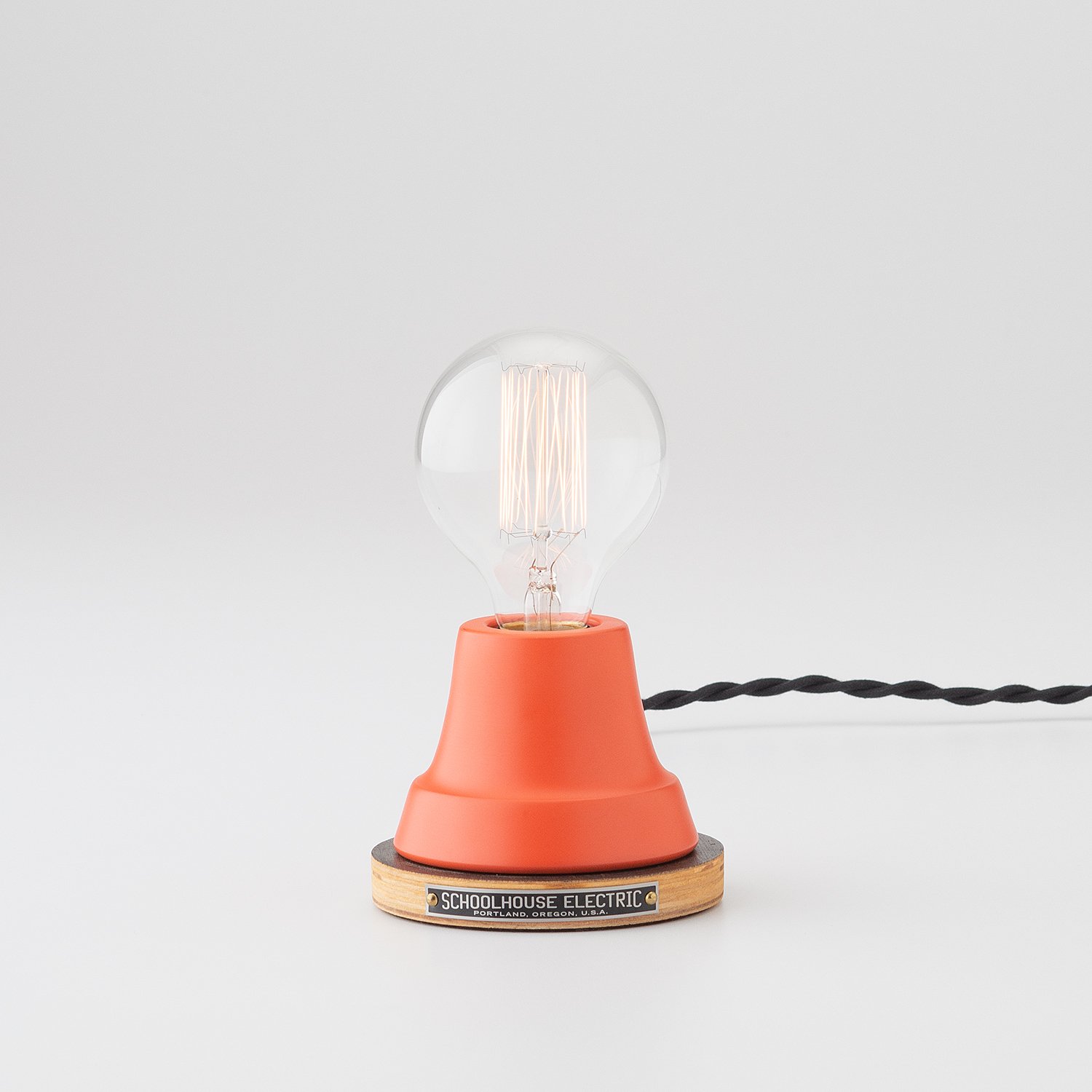 matte red table lamp with visible round light bulb