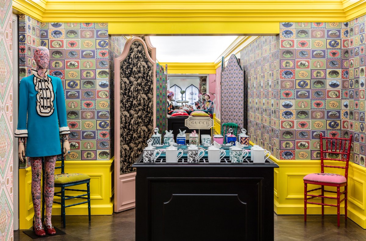 interior of Gucci store with colorful wallpaper and glossy yellow trim