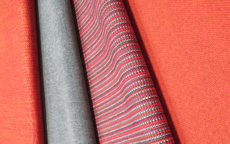 four upholstery fabrics in orange and gray with varied textures