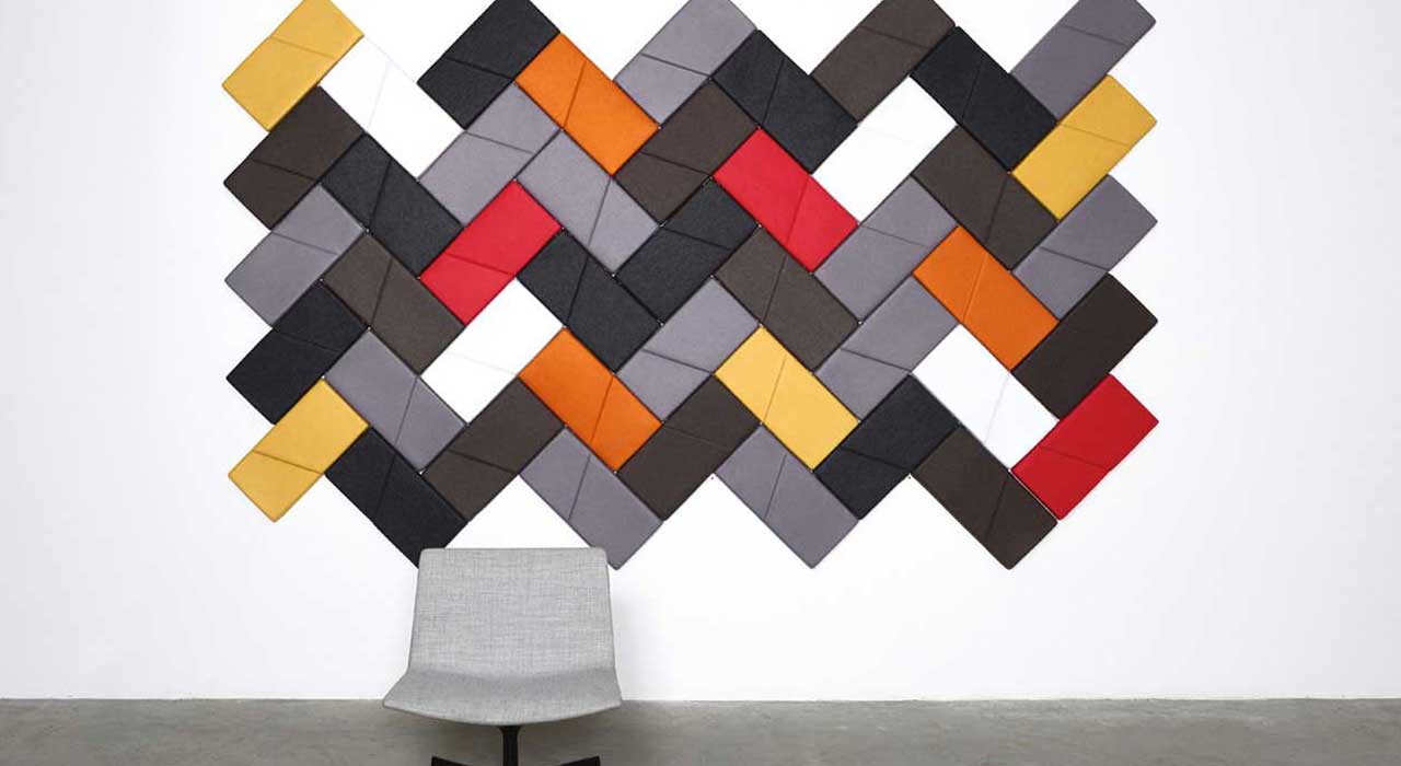 white wall with colorful acoustical tiles in chevron pattern