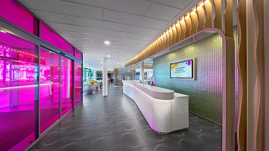 futuristic hotel lobby with neon pink wall and plastic desk
