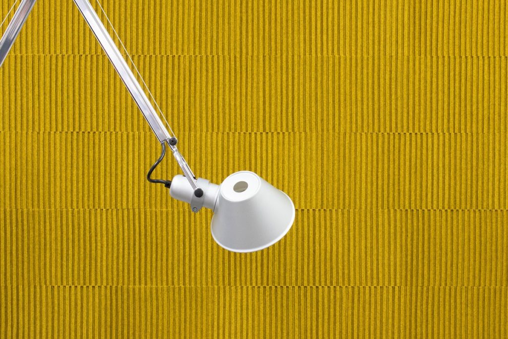 detail of yellow wool acoustic felt with white desk lamp in view