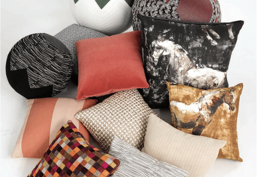 group of pillows upholstered in designer textiles against white background