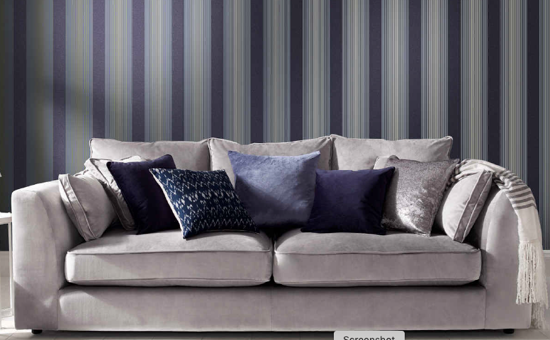 gray velvet couch with navy and blue accent wallpaper
