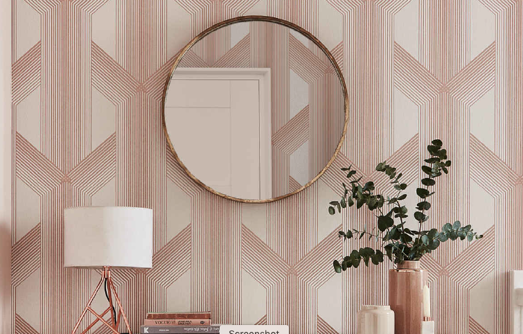 blush and gold geometric wallpaper with lamp and mirror visible