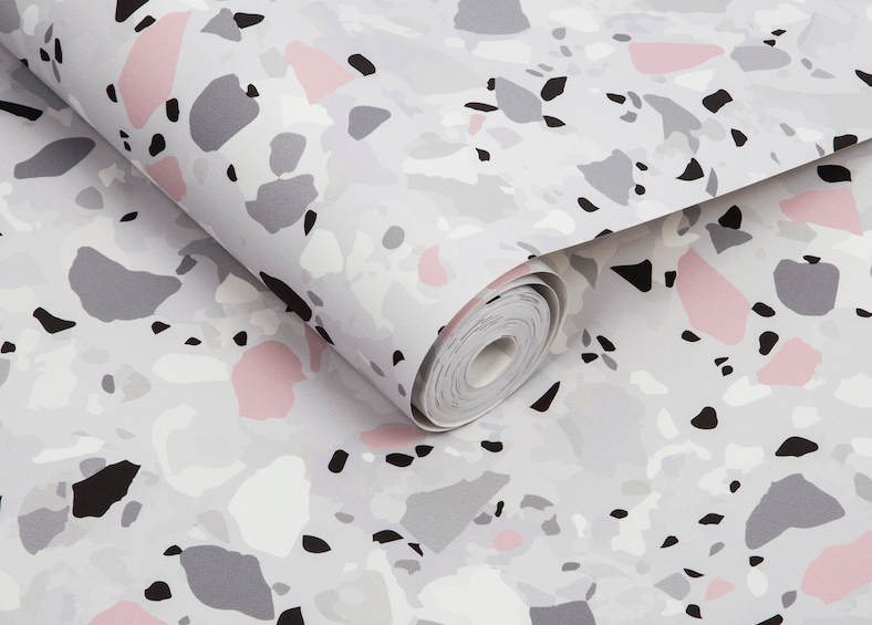 close-up of wallpaper roll with terrazzo pattern in gray, white, and pink