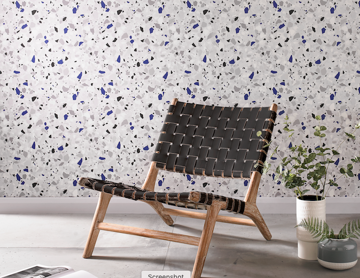 accent wall with terrazzo-inspired wallpaper with blue accents and black and wood modern chair